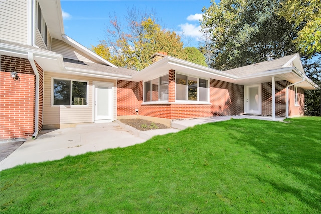 rear view of house with a patio area and a lawn