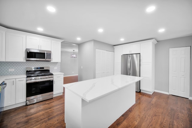 kitchen featuring a kitchen island, dark wood-type flooring, appliances with stainless steel finishes, and white cabinets