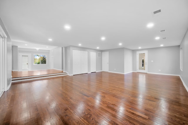 unfurnished living room with hardwood / wood-style flooring and baseboard heating