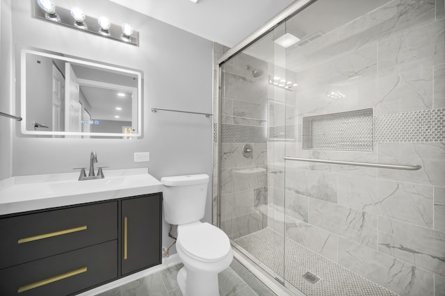 bathroom featuring toilet, vanity, and a shower with door