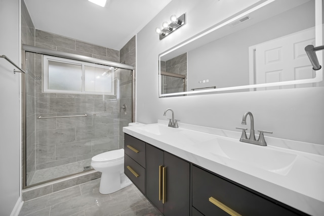 bathroom with vanity, a shower with shower door, and toilet