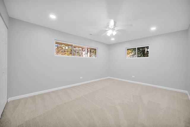 spare room with light carpet, a healthy amount of sunlight, and ceiling fan