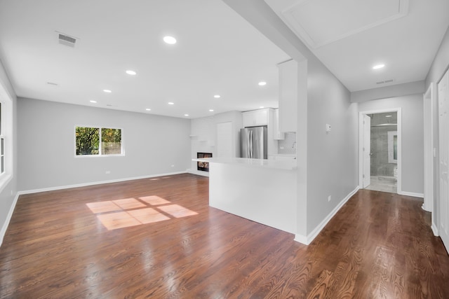 unfurnished living room featuring dark wood-type flooring and a fireplace