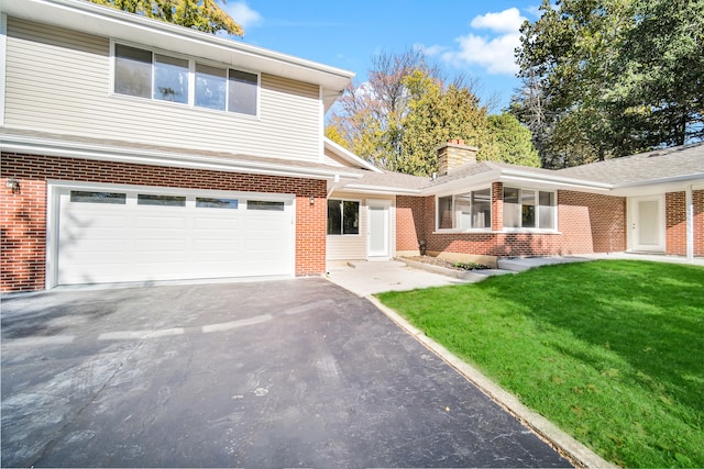 front facade featuring a garage and a front lawn