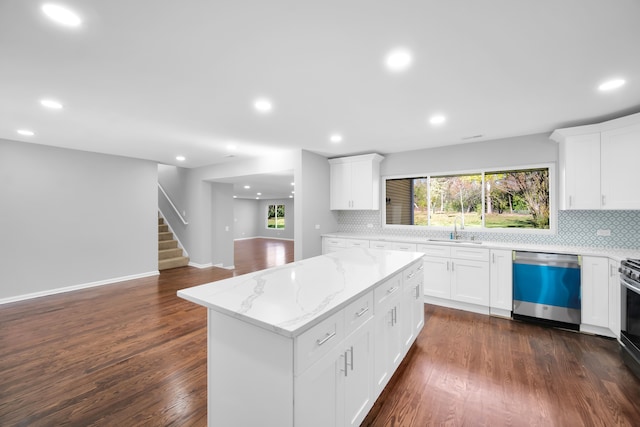 kitchen featuring white cabinetry, appliances with stainless steel finishes, a center island, and dark hardwood / wood-style flooring