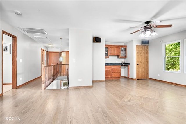 unfurnished living room with light wood-type flooring and ceiling fan