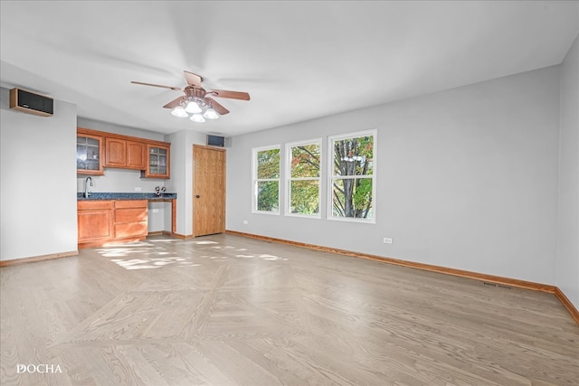 unfurnished living room with sink and ceiling fan