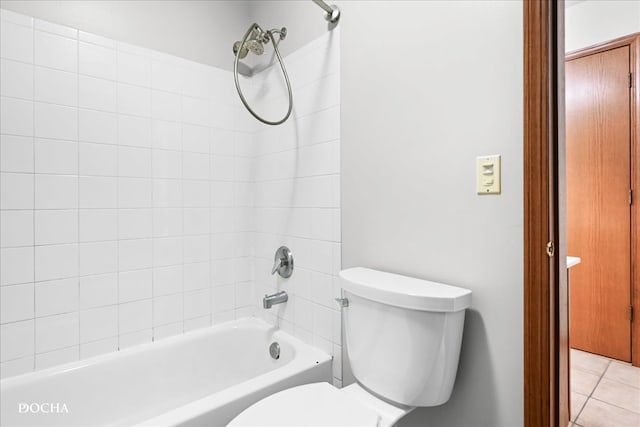 bathroom featuring toilet, tile patterned floors, and tiled shower / bath