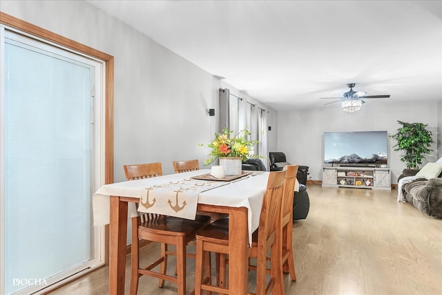 dining area with wood-type flooring and ceiling fan