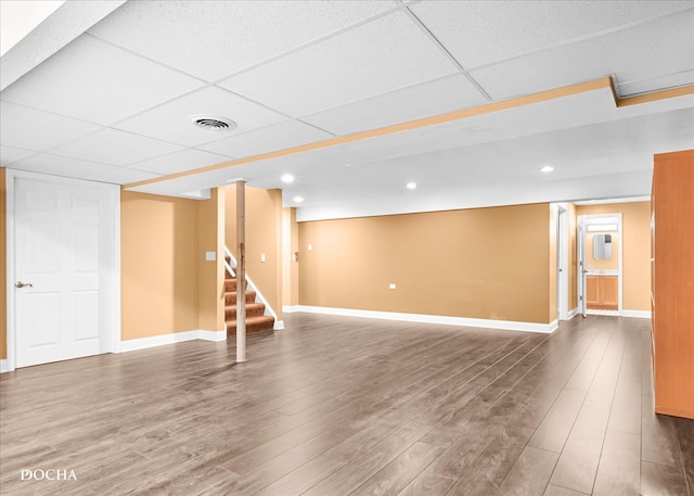 basement featuring wood-type flooring and a drop ceiling