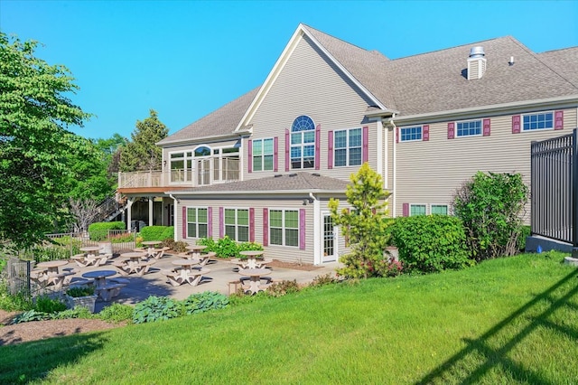 rear view of property with a patio area, a deck, and a yard