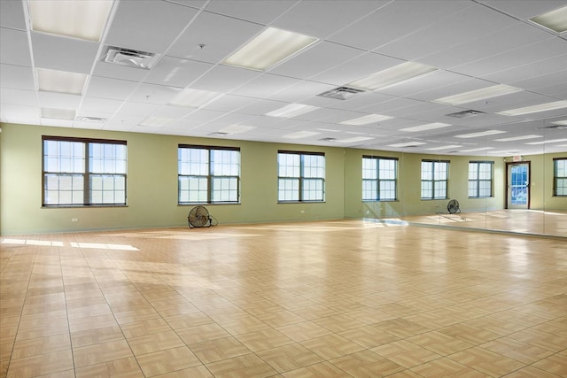 exercise room featuring a drop ceiling and a healthy amount of sunlight