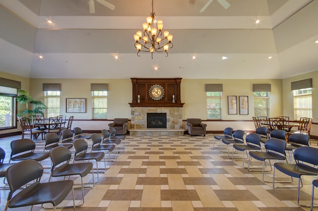 interior space featuring a towering ceiling, ceiling fan with notable chandelier, and a fireplace