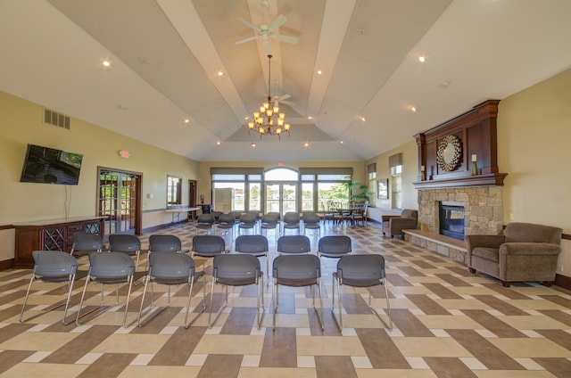 interior space with ceiling fan with notable chandelier, high vaulted ceiling, and a fireplace