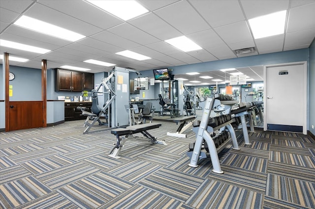 gym featuring a paneled ceiling and carpet flooring