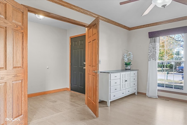 foyer entrance featuring ornamental molding, light wood-type flooring, and ceiling fan