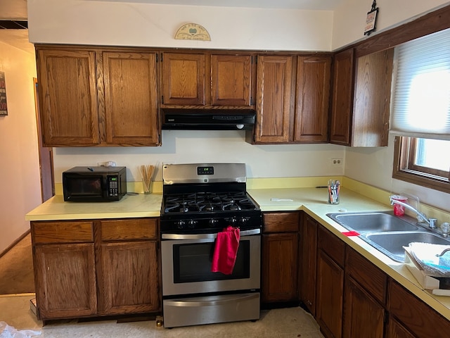 kitchen with gas range, sink, and range hood