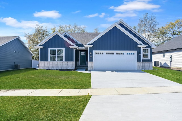 view of front of home with a front yard, central AC, and a garage