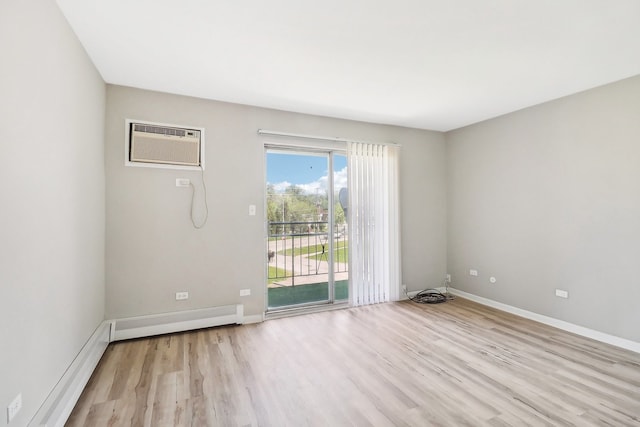 unfurnished room featuring a wall unit AC and light hardwood / wood-style floors