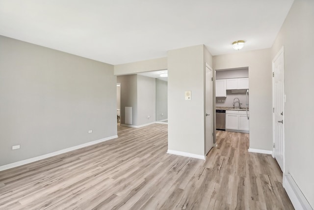 unfurnished living room featuring light hardwood / wood-style floors and sink