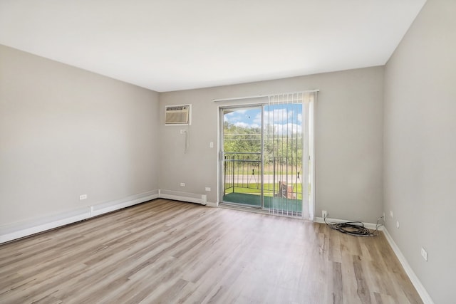 unfurnished room featuring a wall unit AC, light hardwood / wood-style flooring, and baseboard heating