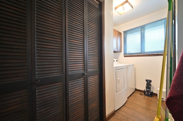 clothes washing area featuring cabinets, washer and clothes dryer, and light wood-type flooring