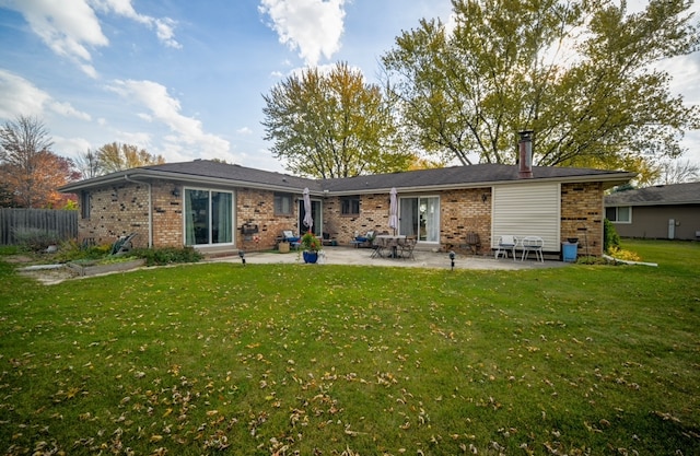 rear view of property with a patio and a lawn