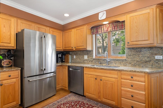 kitchen with sink, stainless steel appliances, light stone countertops, and decorative backsplash