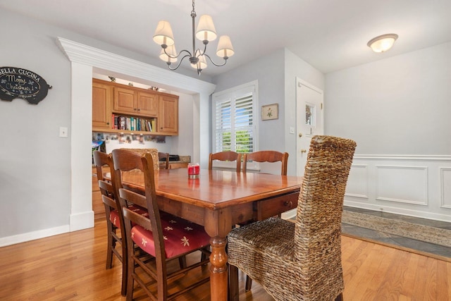 dining area featuring light hardwood / wood-style floors and an inviting chandelier