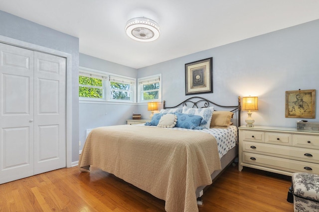 bedroom with light hardwood / wood-style floors and a closet