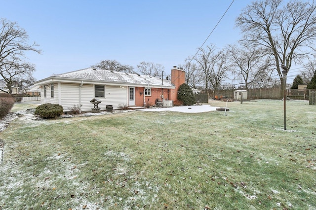 back of property with a lawn, a patio area, and a storage unit