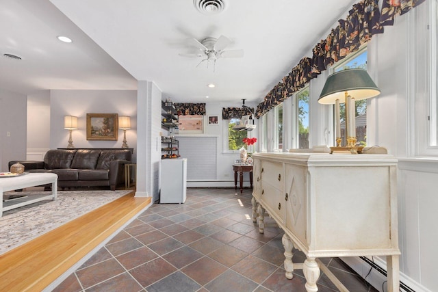 interior space featuring a baseboard heating unit and ceiling fan