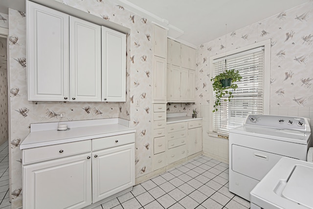 laundry room with cabinets, washing machine and dryer, and light tile patterned floors