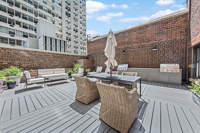 wooden terrace featuring area for grilling and an outdoor hangout area