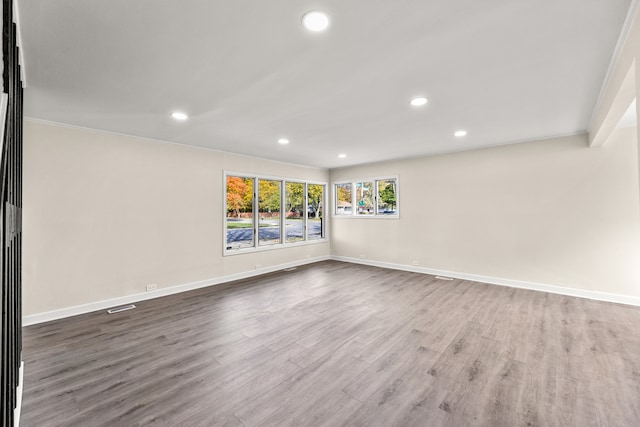 empty room featuring ornamental molding and hardwood / wood-style floors