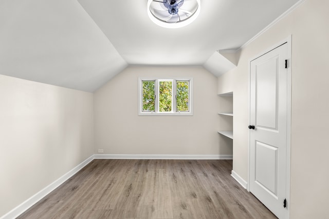 additional living space featuring lofted ceiling, light hardwood / wood-style flooring, and ceiling fan