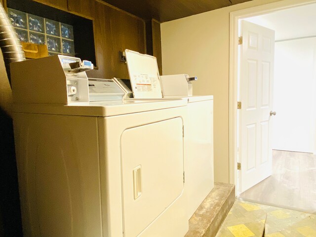 washroom with washing machine and clothes dryer and wood-type flooring