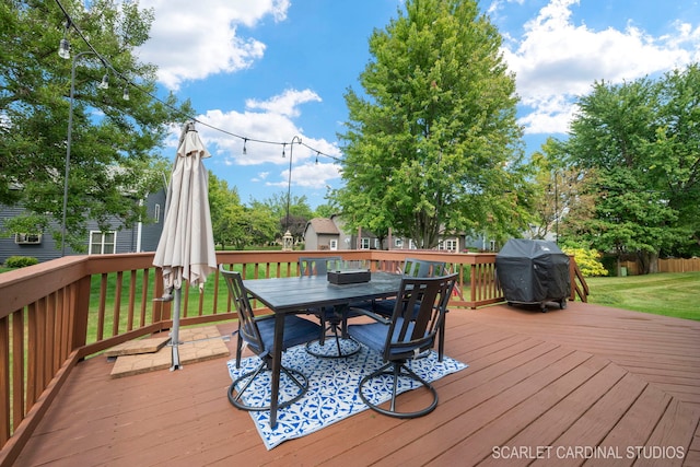 wooden terrace featuring a lawn and grilling area