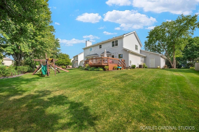 rear view of house with a playground, a lawn, and a wooden deck