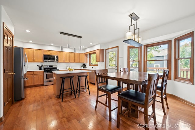 dining space featuring sink, light wood-type flooring, and track lighting