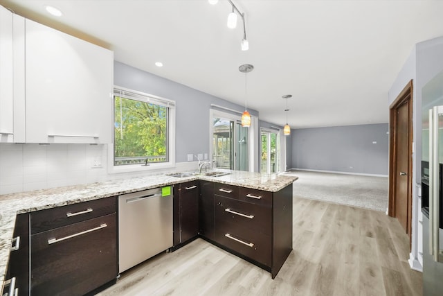 kitchen featuring white cabinetry, dark brown cabinetry, pendant lighting, stainless steel dishwasher, and light hardwood / wood-style flooring