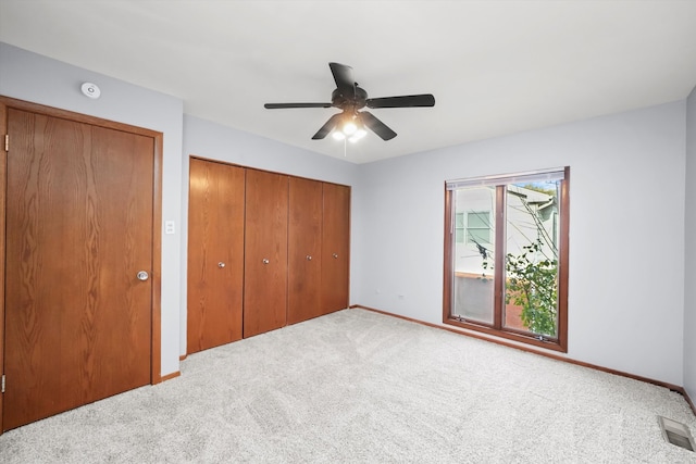 unfurnished bedroom featuring light carpet and ceiling fan