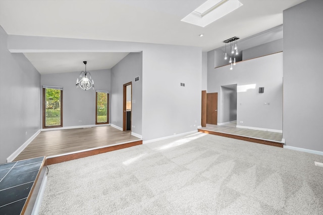 unfurnished living room with lofted ceiling with skylight, hardwood / wood-style floors, and a chandelier