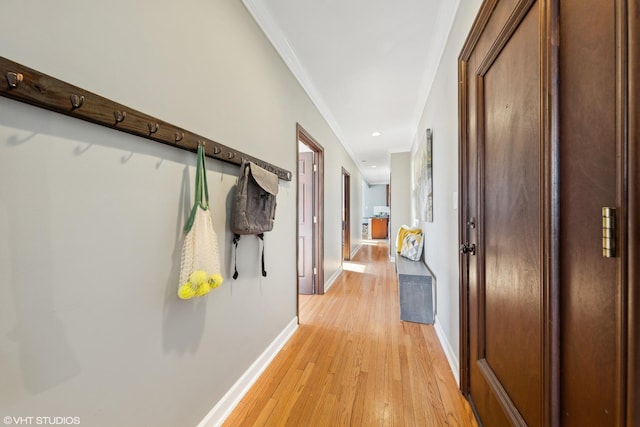 corridor featuring ornamental molding and light wood-type flooring