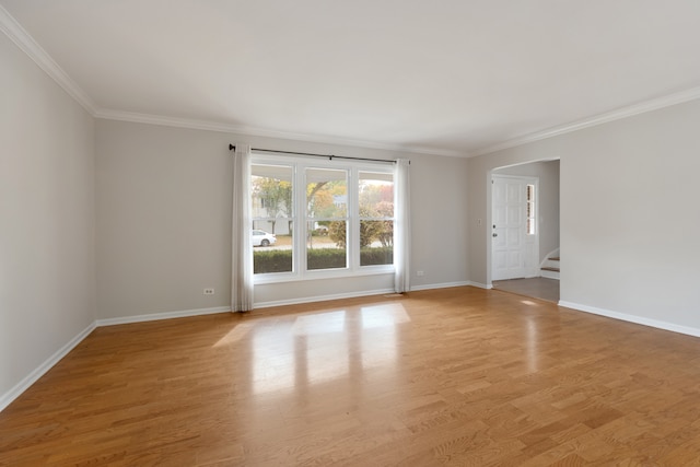 empty room with crown molding and light wood-type flooring