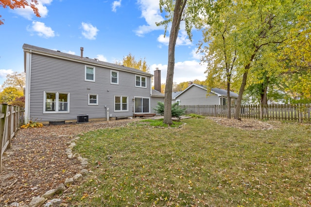 rear view of house with a yard and central AC unit