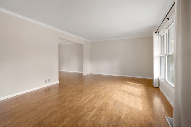 spare room with ornamental molding and light wood-type flooring