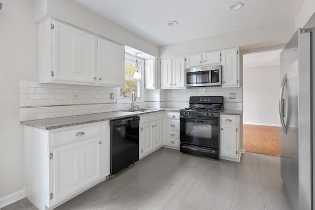 kitchen featuring light stone countertops, black appliances, sink, and white cabinets