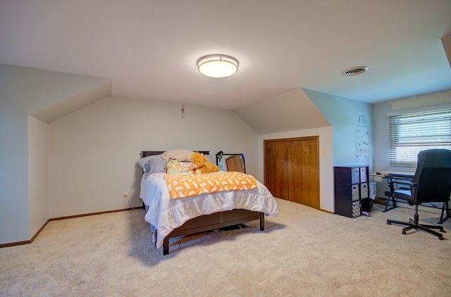 carpeted bedroom with lofted ceiling and a closet