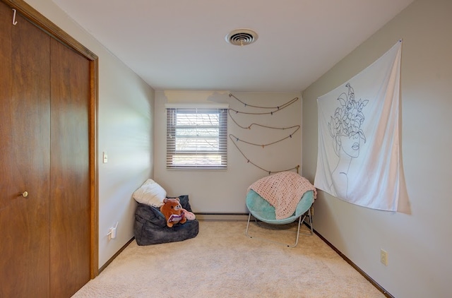 sitting room featuring baseboard heating and light colored carpet